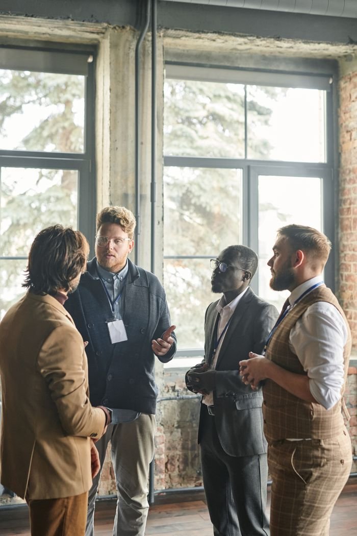 Multiethnic group of businessmen having a discussion in a well-lit office space.